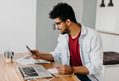 Man using a laptop and smart phone