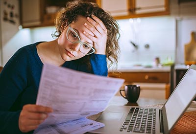 Stressed-out young woman looking at paperwork.