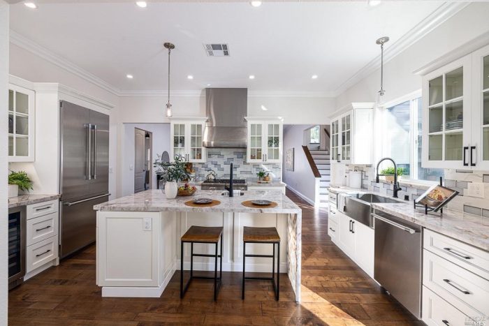 White kitchen pendant hanging lighting hooded stove with subway tile back splash all white with grey accents