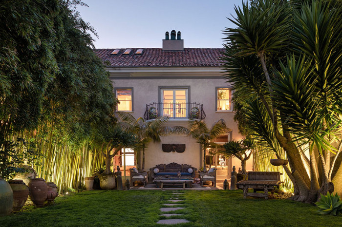 Italian house sea cliff exterior view in yard of palms lit up