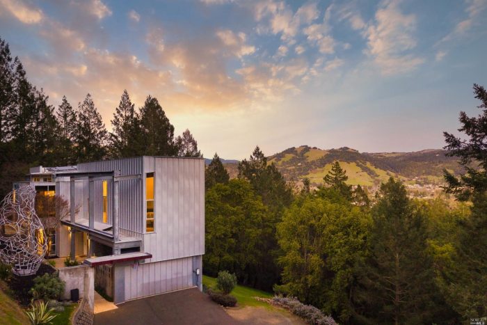 Modern wood siding home with view of valley