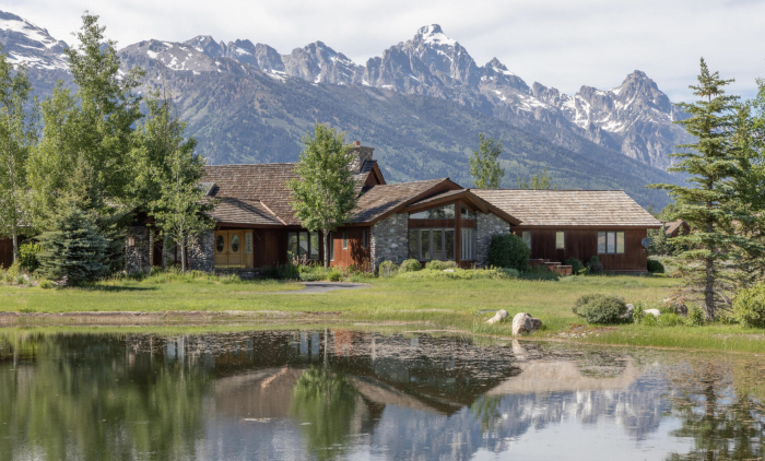 House with Grant Tetons in background lake in foreground