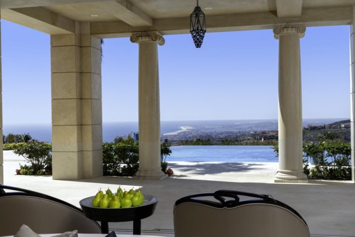 Patio with pears in a bowl, greek columns and an expansive view of Orange County.