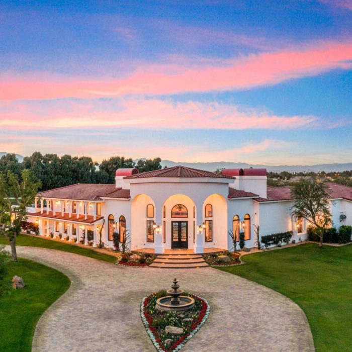 Spanish adobe-sytle home at dusk entrance with fountain