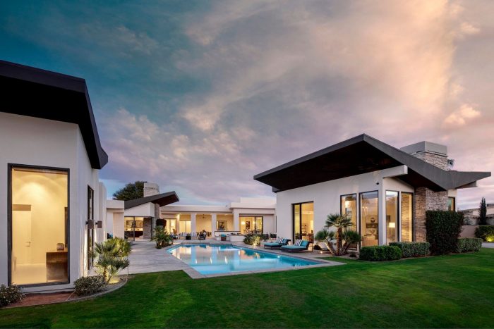 Butterfly Style architecture  with swimming pool clouds overhead after sunset