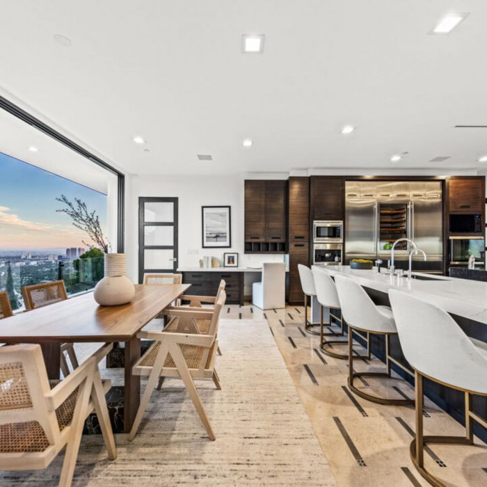 Kitchen and eating area with table stools and plate glass window view of Los Angeles 
