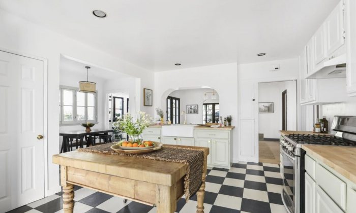 White kitchen with black and white tiles and rustic table - island