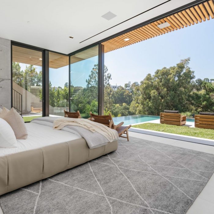 Bedroom with sliding glass doors facing patio and pool