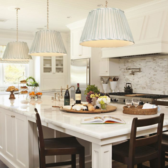 Rustic kitchen in white with black stools with cheese wine board on counter