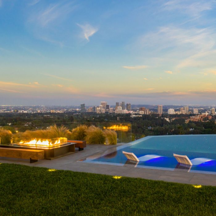Bel air patio with pool and fireplace overlooking downtown Los Angeles just after sunset