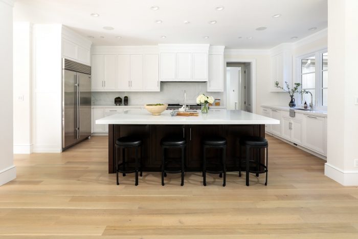 White kitchen with black chairs at island bar