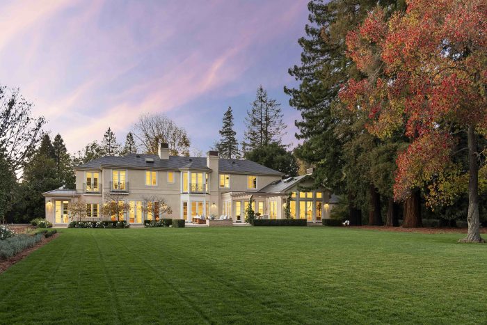 Exterior of house at sunset with interior light on Arbor Rd Menlo Park lawn in foreground