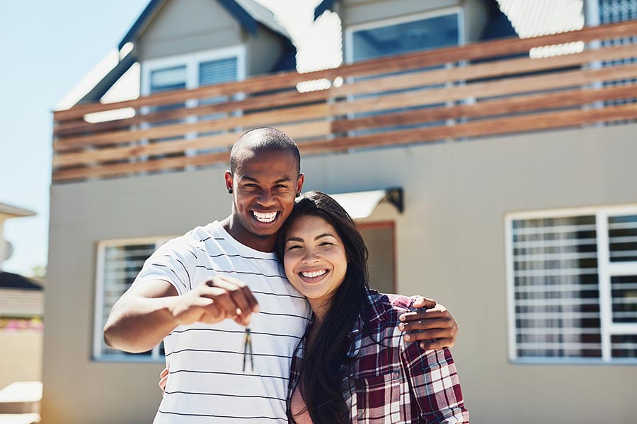 Portrait of a young couple holding the keys to their new home