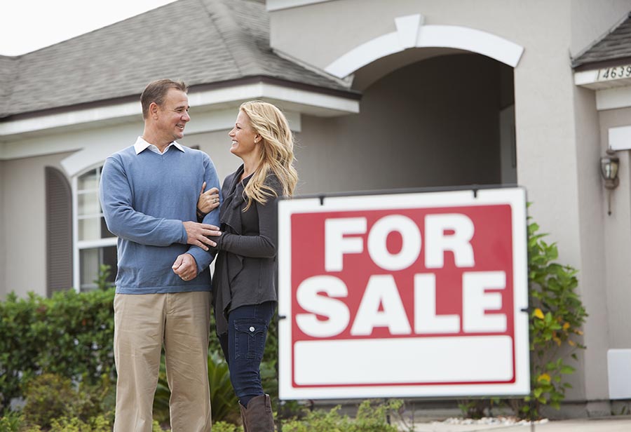 Couple standing in front of house for sale