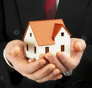 Photo illustration of a man holding a model house