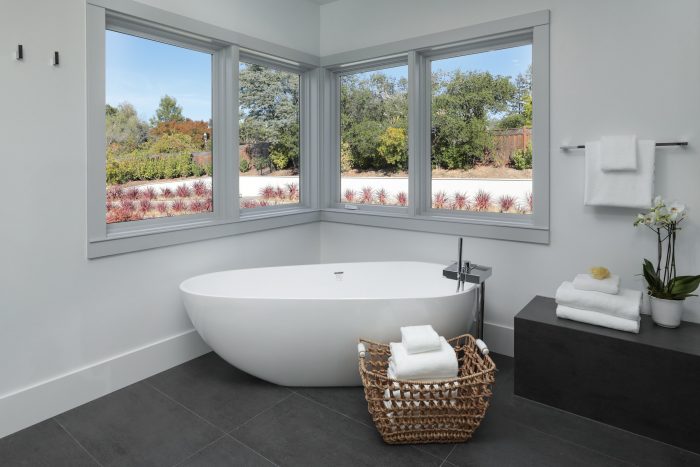 Stand alone tub surrounded by windows. 