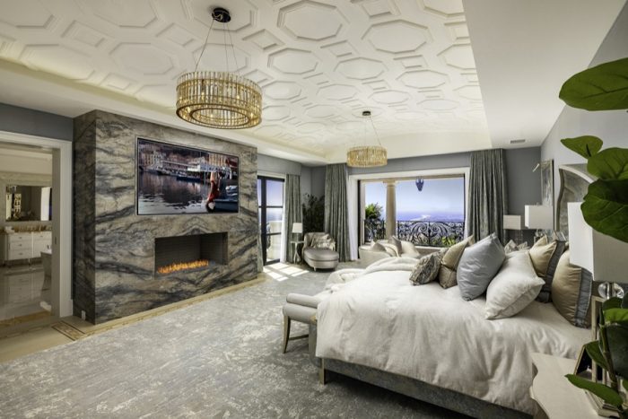 Mater suite with views of OC and a large screen above the fireplace. 