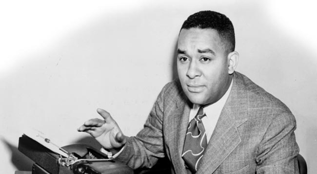 View of Richard Wright, shown gesturing at a typewriter